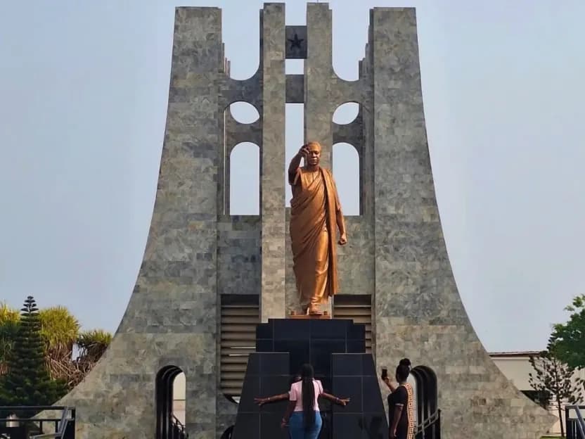 The Kwame Nkrumah Mausoleum in Accra, with its bronze statue of Nkrumah, under a pale sky