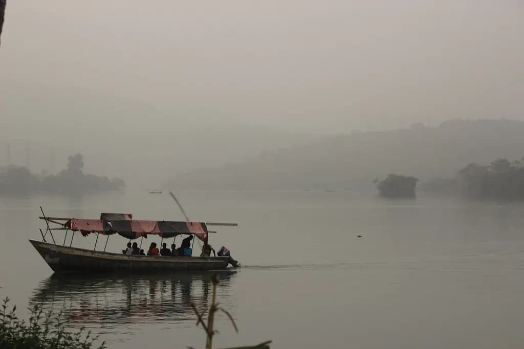 A canopied boat crossing the misty Volta lake at Akosombo